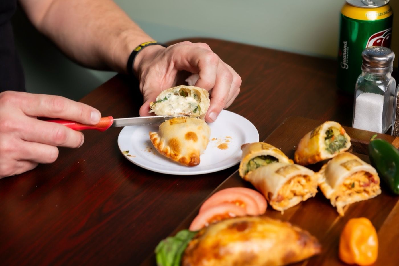 An empanada cut open to show the filling, with more cross sections behind