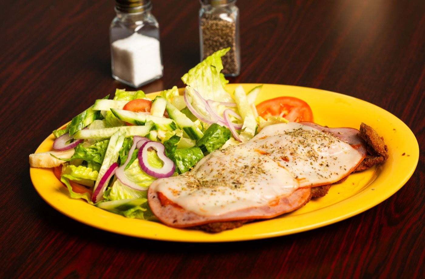 Milanesa plated with salad and fries